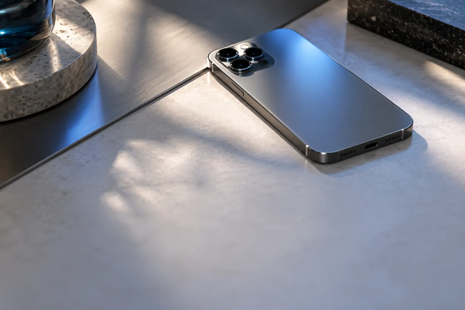 Smartphone posé sur un bureau en titane brossé, sous une lumière rasante froide